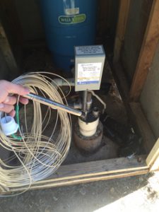 A pressure transducer and the cable installed in a domestic well with a drop tube.